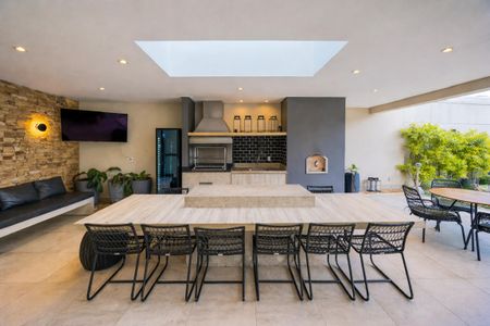 Apartamento à venda com 81m², 2 quartos e 2 vagasComida e bebida no jardim, com uma mesa de madeira e cadeiras de metal, e uma pia de pedra.