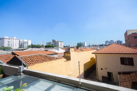 Apartamento à venda com 81m², 2 quartos e 2 vagasVista panorâmica de uma cidade com telhados de telhas e edifícios altos, com um céu azul claro e nublado.