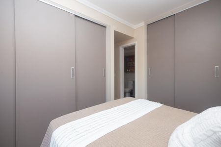 Apartamento à venda com 81m², 2 quartos e 2 vagasQuarto com cama e armários grandes, com uma porta para o banheiro.