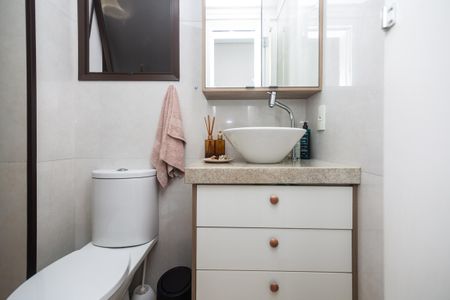 Apartamento à venda com 81m², 2 quartos e 2 vagasBanheiro com piso de porcelanato, pia de cerâmica e armário de madeira.