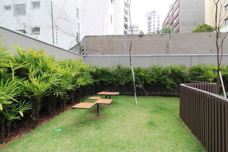 Studio à venda com 29m², 2 quartos e sem vagaJardim com mesa e cadeiras, cercado por muro e arbustos, com vista para edifícios residenciais.