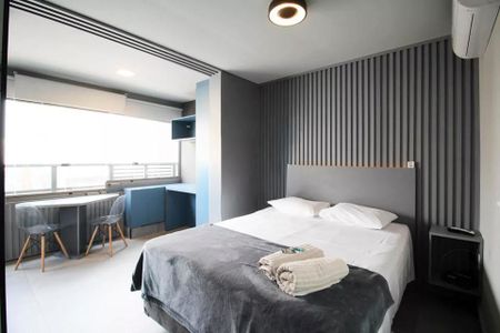 Quarto com cama de casal, mesa e cadeiras, janela e ar condicionado. de kitnet/studio à venda com 2 quartos, 29m² em Itaim Bibi, São Paulo