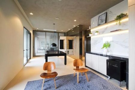 Studio à venda com 29m², 2 quartos e sem vagaSala com mesa de bilhar e duas cadeiras de madeira, com iluminação adequada e acabamento de alta qualidade.