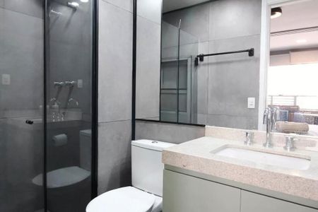 Studio à venda com 29m², 2 quartos e sem vagaBanheiro com piso de porcelanato, pia e vaso sanitário brancos, e espelho grande.
