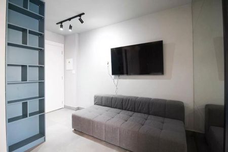 Sala com sofá, TV e prateleiras de madeira, iluminada por lâmpadas de LED. de kitnet/studio à venda com 2 quartos, 29m² em Itaim Bibi, São Paulo