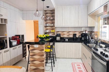 Casa à venda com 136m², 4 quartos e 2 vagas Casa à venda com 136m², 4 quartos e 2 vagasCozinha moderna com iluminação adequada e móveis de madeira, com uma mesa de centro e uma bancada de granito.