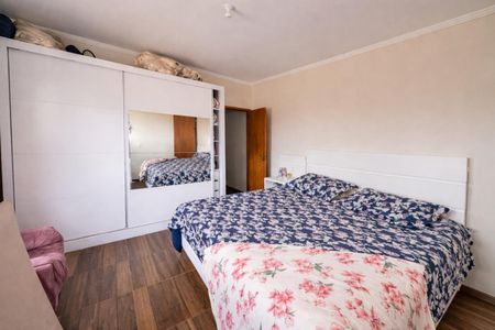 Quarto com cama de casal, armário com espelho e porta de vidro, piso de madeira e teto branco. de casa à venda com 4 quartos, 136m² em Vila Francisca, Campinas