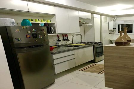 Cozinha com geladeira, fogão e micro-ondas, com móveis brancos e azuis, e utensílios de cozinha. de apartamento à venda com 1 quarto, 38m² em Umuarama, Osasco