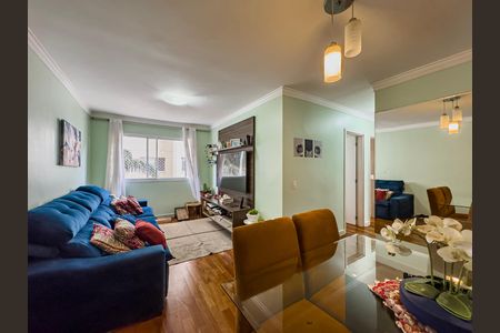 Sala de estar com sofá azul e mesa de vidro, iluminada por lâmpadas de design. de apartamento à venda com 3 quartos, 64m² em Paulicéia, São Bernardo do Campo