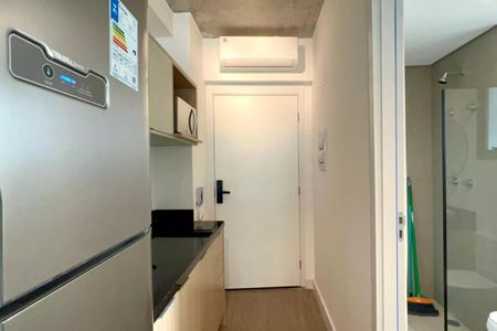 Apartamento à venda com 24m², 1 quarto e sem vagaCozinha com geladeira, micro-ondas e pia, com iluminação boa e acabamento de madeira no piso e na parede da pia.