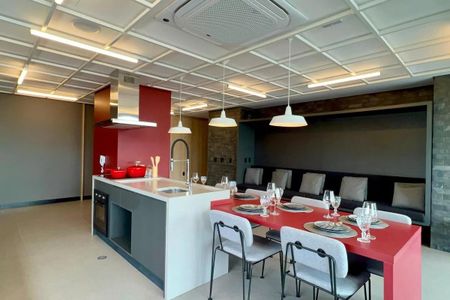 Apartamento à venda com 24m², 1 quarto e sem vagaCozinha moderna com iluminação adequada e móveis em tons de vermelho e branco.