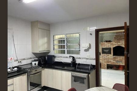 Cozinha com móveis de madeira, fogão, geladeira e churrasqueira, com vista para a varanda. de casa à venda com 3 quartos, 140m² em Vila Tiradentes, São Paulo