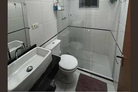 Banheiro com piso de porcelanato, vaso sanitário e chuveiro, com espelho e prateleira de sabonetes. de casa à venda com 3 quartos, 140m² em Vila Tiradentes, São Paulo