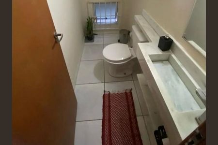 Banheiro com piso de porcelanato, pia de granito e vaso sanitário branco. de casa à venda com 3 quartos, 140m² em Vila Tiradentes, São Paulo