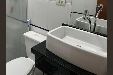 Banheiro com pia e vaso sanitário brancos, com espelho e chuveiro, em ambiente simples e limpo. de casa à venda com 3 quartos, 140m² em Vila Tiradentes, São Paulo