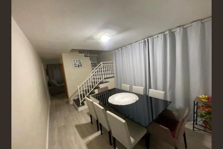 Sala de jantar com mesa de vidro e cadeiras brancas, com vista para a escada e a entrada. de casa à venda com 3 quartos, 140m² em Vila Tiradentes, São Paulo