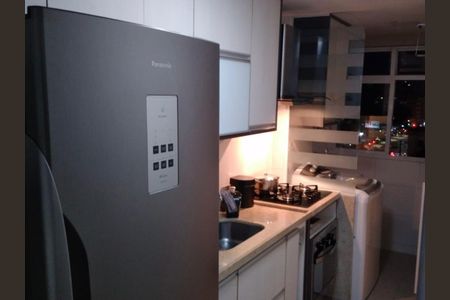 Cozinha moderna com geladeira, fogão e pia, iluminada com luzes brancas, com vista para a cidade à noite. de apartamento à venda com 2 quartos, 66m² em Centro, Niterói