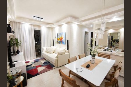 Sala de estar com sofá branco, mesa de jantar e TV, iluminada com luzes brancas e decorada com plantas e quadros de arte. de apartamento à venda com 2 quartos, 66m² em Centro, Niterói