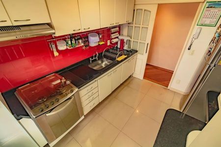 Apartamento à venda com 265m², 5 quartos e 3 vagasCozinha com móveis brancos, pia e fogão de aço inox, e piso de porcelanato.