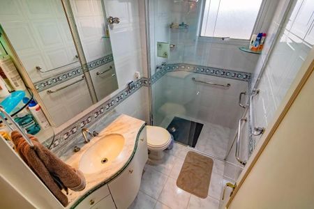 Apartamento à venda com 265m², 5 quartos e 3 vagasBanheiro com piso de porcelanato, pia de mármore e chuveiro de vidro.
