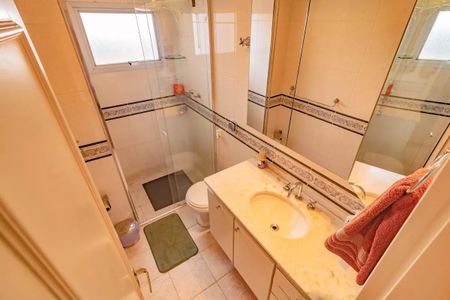 Apartamento à venda com 265m², 5 quartos e 3 vagasBanheiro com piso de porcelanato, pia de mármore e espelho grande.