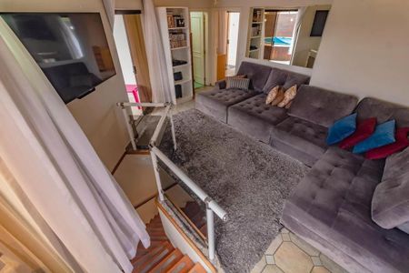 Apartamento à venda com 265m², 5 quartos e 3 vagasSala de estar com sofá, TV e estante de livros, com vista para a piscina.