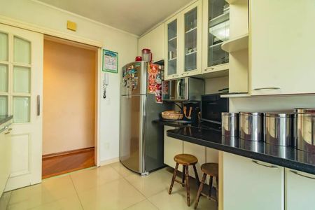 Apartamento à venda com 265m², 5 quartos e 3 vagasCozinha com geladeira, fogão e móveis brancos, com iluminação boa e bem decorada.