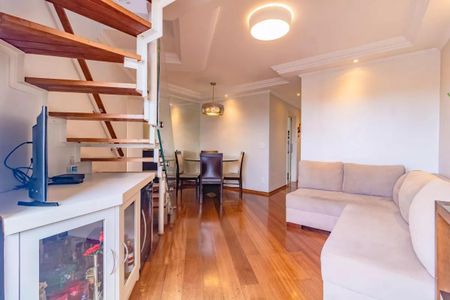 Apartamento à venda com 265m², 5 quartos e 3 vagasSala de estar com sofá, TV e escada de madeira, iluminada por lâmpadas e com vista para a cidade.