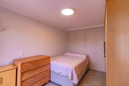 Apartamento à venda com 265m², 5 quartos e 3 vagasQuarto simples com cama e móveis de madeira, iluminado por uma lâmpada circular.