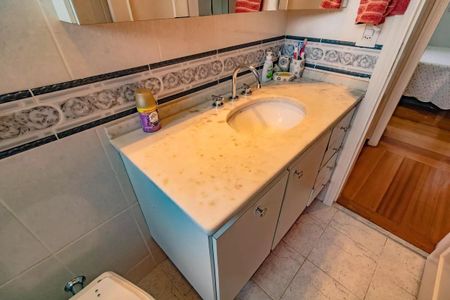 Apartamento à venda com 265m², 5 quartos e 3 vagasVidro de banheiro com desenho de flores e um espelho grande acima do lavabo.