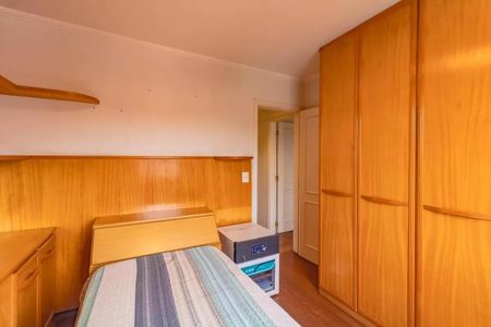 Apartamento à venda com 265m², 5 quartos e 3 vagasQuarto simples com cama e móveis de madeira, com uma porta de entrada e uma janela pequena.