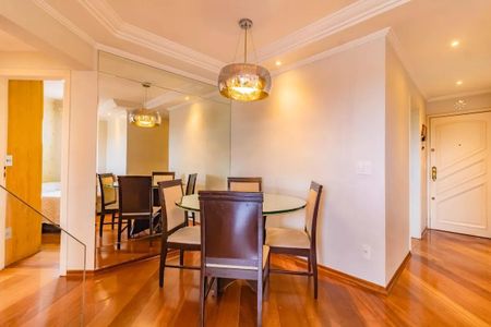 Apartamento à venda com 265m², 5 quartos e 3 vagasSala de jantar com mesa redonda e cadeiras de madeira e tecido, iluminada por lâmpada de design e com espelho na parede.