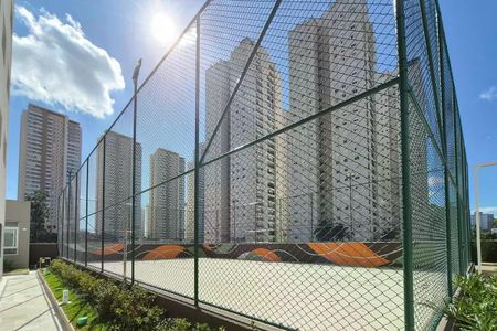 Apartamento à venda com 117m², 3 quartos e 2 vagasPraça de tênis com vista para edifícios residenciais altos, com sol brilhando no fundo.