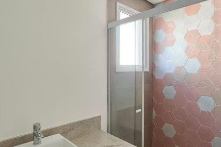 Apartamento à venda com 117m², 3 quartos e 2 vagasBanheiro com piso de azulejos, chuveiro e pia branca, com uma janela pequena.