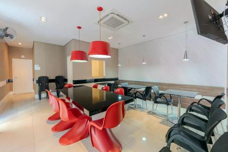 Apartamento à venda com 34m², 1 quarto e 1 vagaSala com mesa e cadeiras vermelhas e brancas, iluminada por lâmpadas vermelhas e com uma TV na parede.