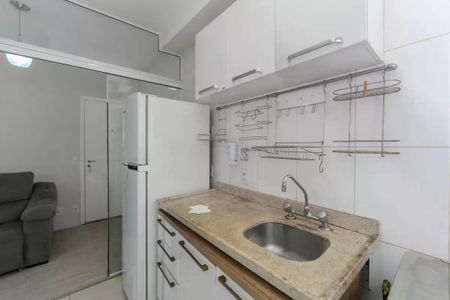 Apartamento à venda com 34m², 1 quarto e 1 vagaCozinha com geladeira, pia e armários brancos, com iluminação adequada e acabamento de madeira.
