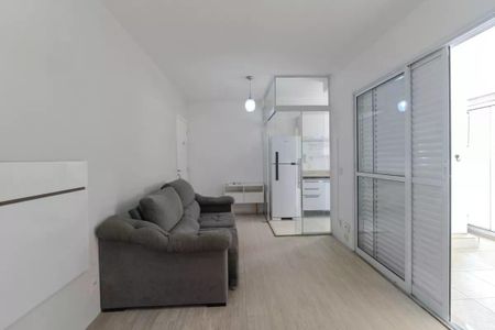 Apartamento à venda com 34m², 1 quarto e 1 vagaSala com sofá, geladeira e cozinha em fundo branco e madeira de parquete.