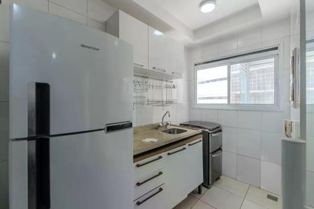 Apartamento à venda com 34m², 1 quarto e 1 vagaCozinha com geladeira, fogão e pia, com iluminação boa e acabamento de madeira e pedra.