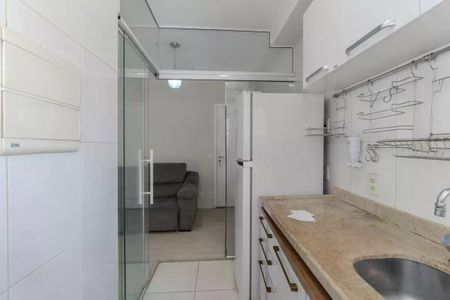 Apartamento à venda com 34m², 1 quarto e 1 vagaCozinha com geladeira, fogão e pia, com iluminação boa e acabamento de madeira e pedra.