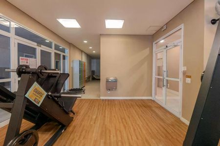 Apartamento à venda com 34m², 1 quarto e 1 vagaGym with black equipment and wooden floor, water fountain on the wall, and glass doors leading to the hallway.