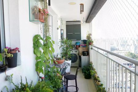 Apartamento à venda com 57m², 2 quartos e 1 vagaVaranda com vista para a cidade, com móveis e plantas, e uma lavadora no fundo.