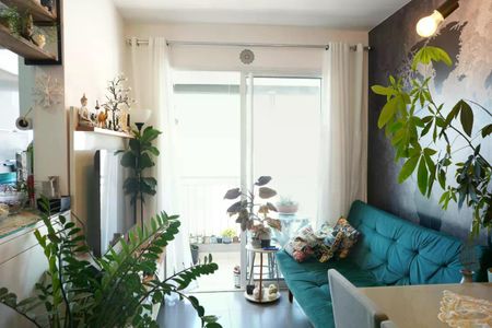 Sala com sofá azul, mesa e cadeiras, janelas grandes e iluminação natural, com plantas e decoração simples. de apartamento à venda com 2 quartos, 57m² em Brás, São Paulo