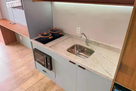 Apartamento à venda com 28m², 1 quarto e sem vagaCozinha com pia, fogão e micro-ondas, com móveis em tons de azul e madeira, e piso de cerâmica.