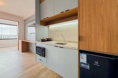 Apartamento à venda com 28m², 1 quarto e sem vagaCozinha moderna com móveis em madeira e piso de porcelanato, equipada com geladeira e fogão.