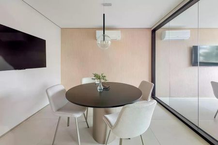Tabela redonda com quatro cadeiras brancas e uma planta em um ambiente moderno e minimalista. de apartamento para alugar com 1 quarto, 28m² em Ipiranga, São Paulo