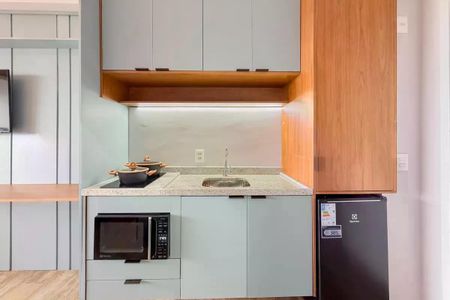 Apartamento à venda com 28m², 1 quarto e sem vagaCozinha com geladeira, fogão e pia, com móveis de madeira e azul claro, e pia de granito.