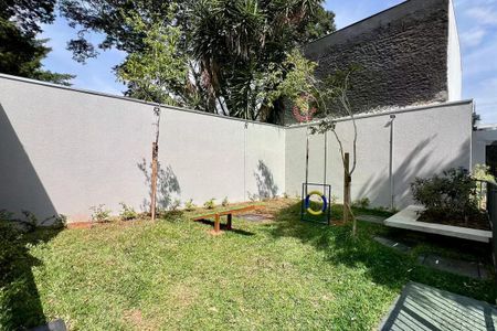 Apartamento à venda com 25m², 1 quarto e sem vagaJardim com bancos e brinquedos para crianças, cercado por uma parede branca e com uma casa de técnicas ao fundo.