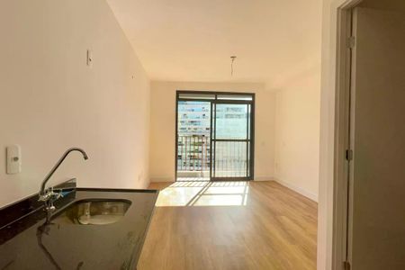 Apartamento à venda com 25m², 1 quarto e sem vagaCozinha com piso de madeira, pia e torneira de água quente, com vista para a varanda e o prédio ao fundo.