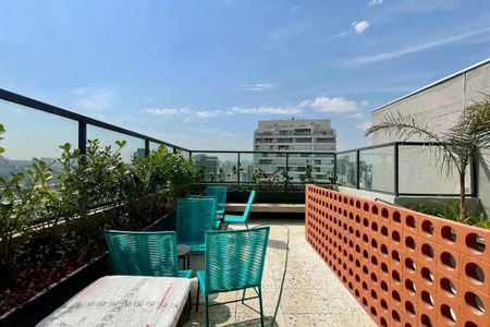 Apartamento à venda com 25m², 1 quarto e sem vagaVaranda com vista para a cidade, com móveis em tons de azul e verde, e plantas ao redor.