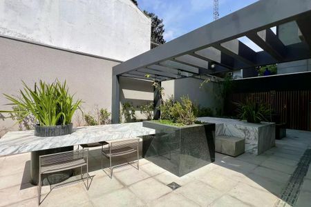 Apartamento à venda com 25m², 1 quarto e sem vagaPátio com mesa de mármore e cadeiras de metal, com plantas e jardim ao redor.